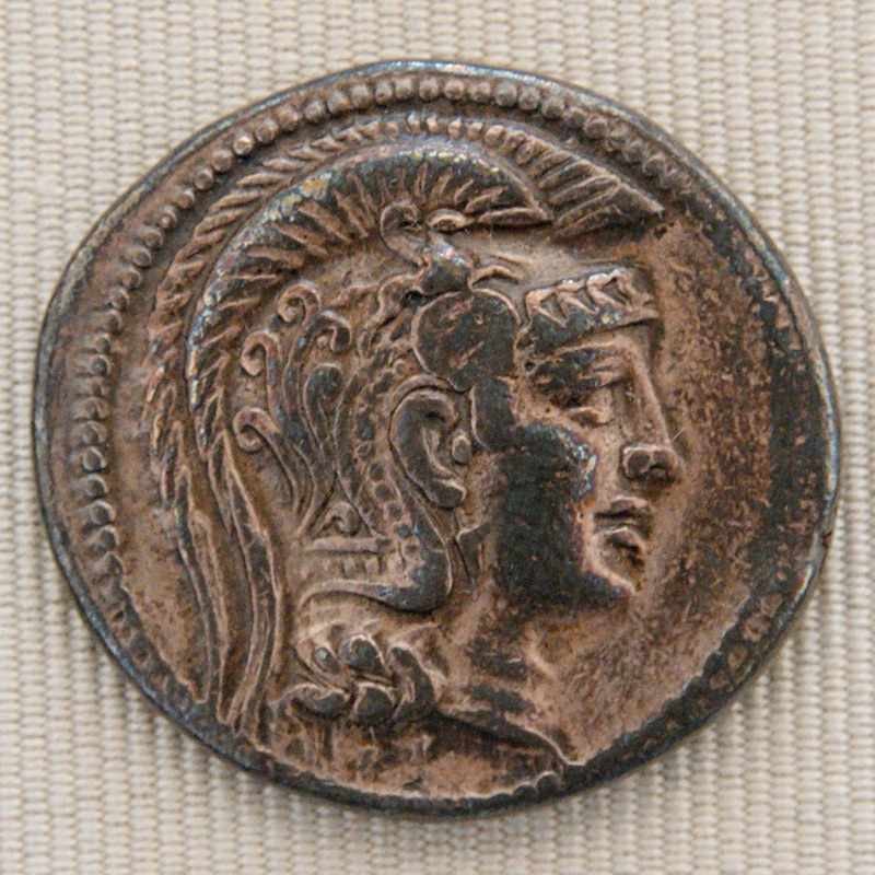 An elaborate helmet and naturalistic profile of Athena on a broad New Style silver coin.